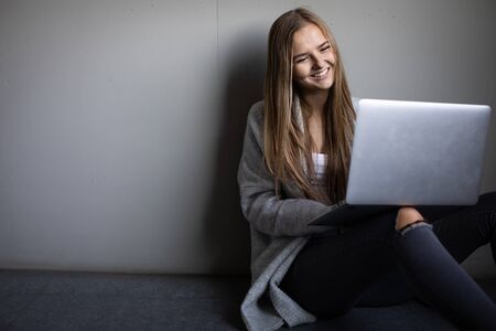 Pretty, young woman with her laptop studying for an exam/working