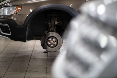 Car mechanic changind tires of a car in a repair shop/car garage (shallow DOF/color toned image)