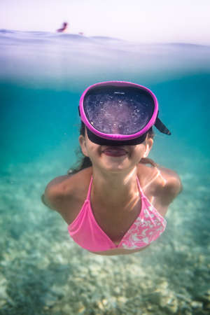 LIttle girl swimming underwater in the sea, enjoying summer fully