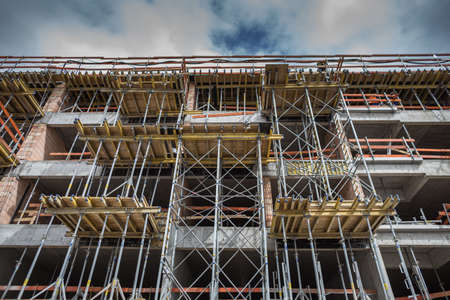 modern urban building under construction with a crane and blue skyの写真素材