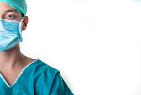 Young male doctor holding a clipboard and wearing a medical face mask isolated on white backgroundの写真素材