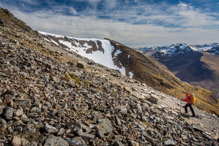 Pretty, young female hiker going uphill in beautiful highlands of Scotland