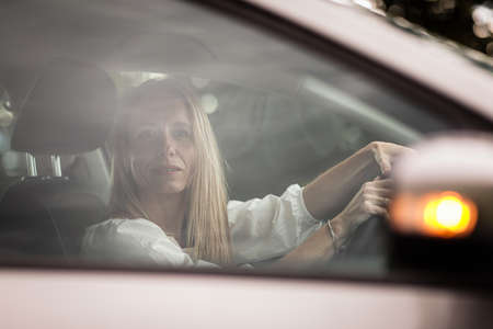 Pretty midle aged woman at the steering wheel of her car commuting to workの写真素材