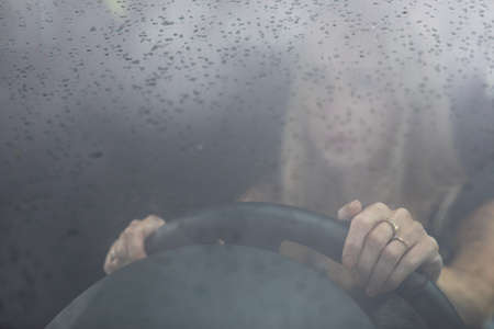 Pretty midle aged woman at the steering wheel of her car commuting to workの写真素材