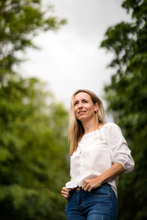 Portrait of a relaxed middle aged woman outdoors, looking happy, enjoying the lifeの写真素材