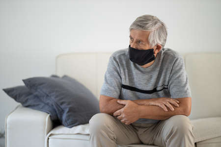 Senior man wearing  a facemask during coronavirus and flu outbreak. Virus and illness protection, home quarantine. COVID-19 conceptの写真素材