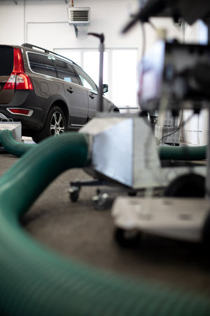 Car mechanic changind tires of a car in a repair shop/car garage (shallow DOF/color toned image)の写真素材