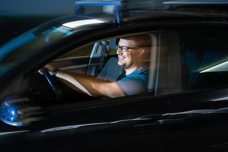 Handsome young driver driving hic car fast yet safely on the roadの写真素材