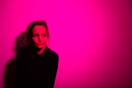 Depressed mid-aged woman at home feeling sad, lonely, anxious (color toned image)の写真素材
