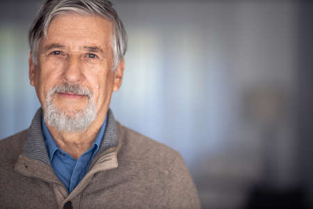 Portrait of happy senior man smiling at home. Close up face of elderly guy enjoying retirement.の写真素材