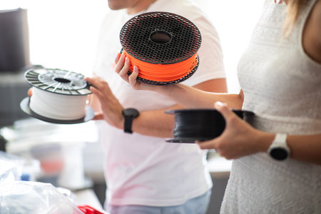 3D Printer Plastic filament for 3D printer and printed products in the hands of a young manの写真素材