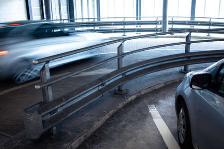 Underground parking. Cars parked in a garage with no people. Many cars in parking garage interior. Underground parking with cars (color toned image)の写真素材