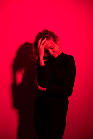 Depressed mid-aged woman at home feeling sad, lonely, anxious (color toned image)の写真素材
