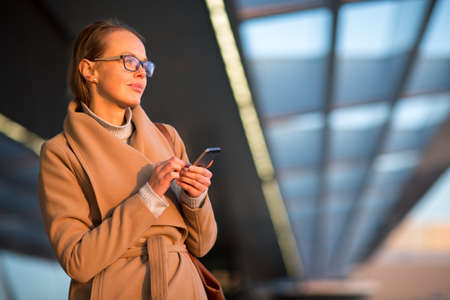 Young female passenger looking for her flight - it is being delayed for long hoursの写真素材