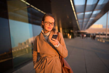 Young female passenger looking for her flight - it is being delayed for long hoursの写真素材