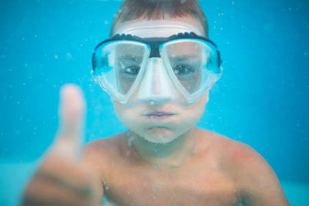 Cute little boy in a swimming poolの写真素材