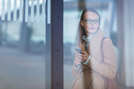 Young female passenger looking for her flight - it is being delayed for long hoursの写真素材