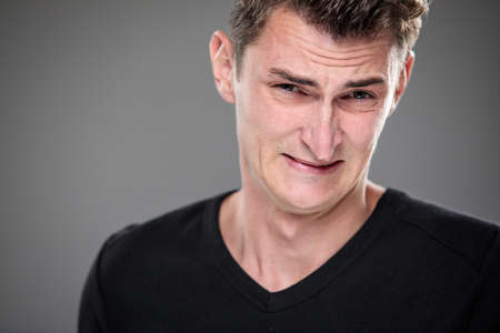 Fear/anxiety/regret/uncertainty in a young man - effects of a difficult life situation - vivid emotions conceptの写真素材