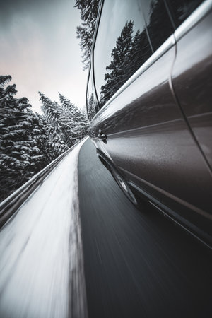 Fast moving car on a winter alpine snowy roadの写真素材