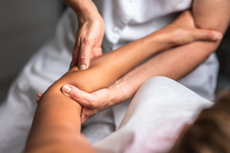 Massage procedure - neck and whole body massage by a female masseuse. doing massaging using oil. neck and whole body massage, relaxing massage, strong hands of a masseur, massage to increase work efficiencyの写真素材