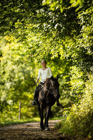 Woman riding a horse. Equestrian sport, leisure horse riding conceptの写真素材