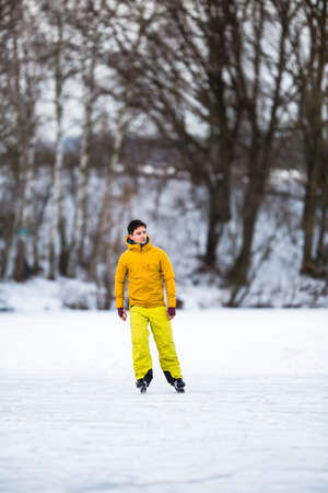 Young man ice skating outdoors on a pond on a freezing winter dayの写真素材