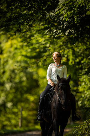 Woman riding a horse. Equestrian sport, leisure horse riding conceptの写真素材