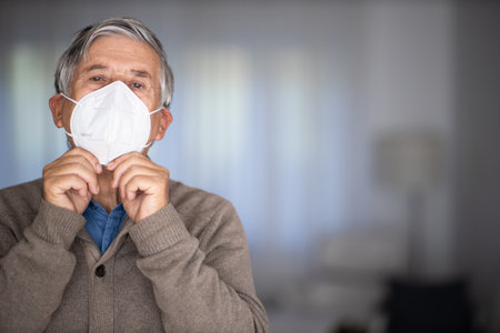 Senior man wearing  a facemask during coronavirus and flu outbreak. Virus and illness protection, home quarantine. COVID-19 conceptの写真素材