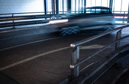 Underground parking. Cars parked in a garage with no people. Many cars in parking garage interior. Underground parking with cars (color toned image)の写真素材