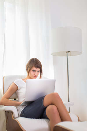Young woman with laptop in her comfortable apartmentの写真素材