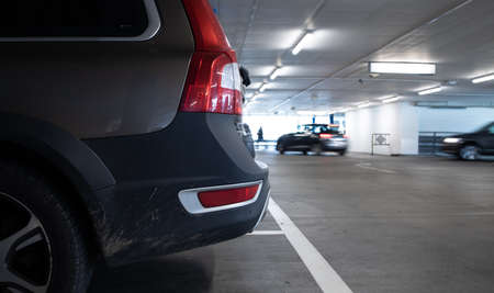 Underground parking. Cars parked in a garage with no people. Many cars in parking garage interior. Underground parking with cars (color toned image)の写真素材