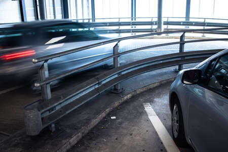 Underground parking. Cars parked in a garage with no people. Many cars in parking garage interior. Underground parking with cars (color toned image)の写真素材
