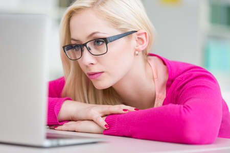 Pretty young college student in a library (shallow DOF; color toned image)の写真素材