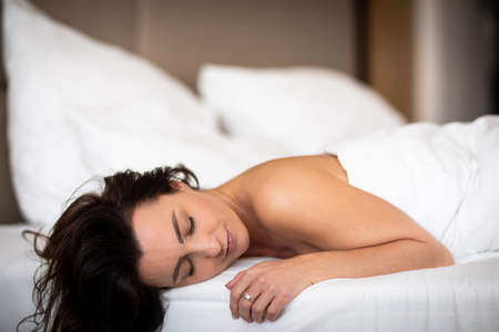 Beautiful young woman sleeping in bedの写真素材
