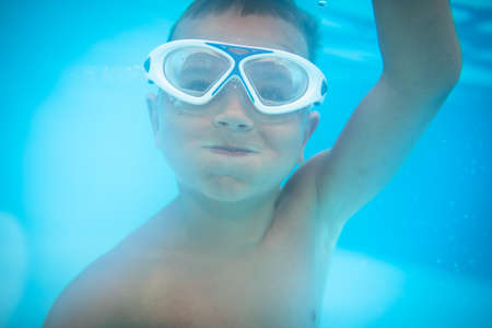 Cute little boy in a swimming poolの写真素材