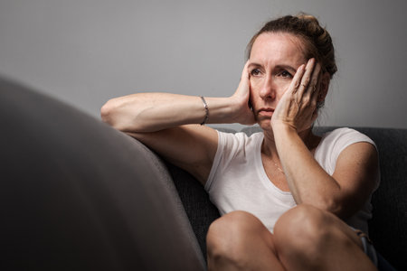 Painful realization - Depressed mid-aged woman at home feeling sad, lonely, anxious (color toned image)の写真素材