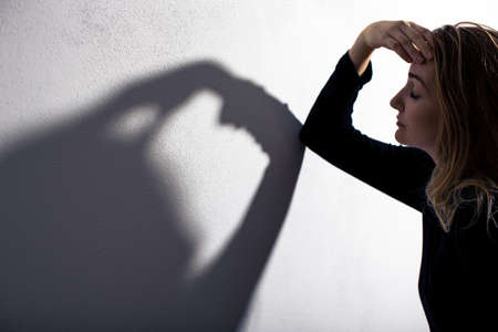 Depressed mid-aged woman at home feeling sad, lonely, anxious (color toned image)の写真素材