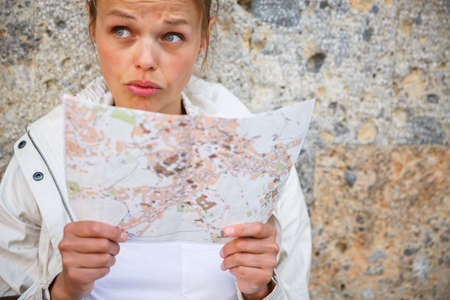Female tourist with a map discovering a foreign city (shallow DOF; color toned image)の写真素材