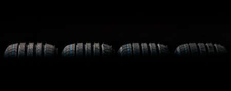 Stack of brand new high performance car tires on clean high-key white studio background