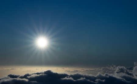 Sky above clouds with sun shining intensely - Earth's atmosphere concept