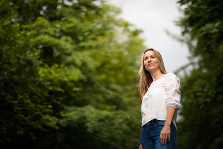 Portrait of a relaxed middle aged woman outdoors, looking happy, enjoying the lifeの写真素材