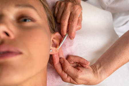 Massage procedure - neck and whole body massage by a female masseuse. doing massaging using oil. neck and whole body massage, relaxing massage, strong hands of a masseur, massage to increase work efficiencyの写真素材