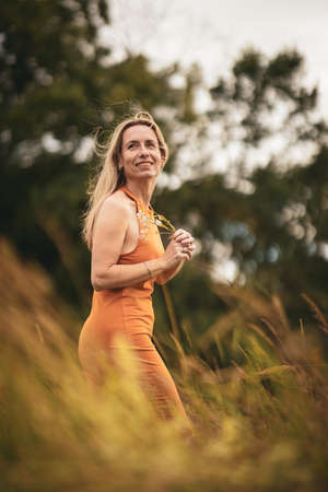 Portrait of a relaxed middle aged woman outdoors, looking happy, enjoying the lifeの写真素材