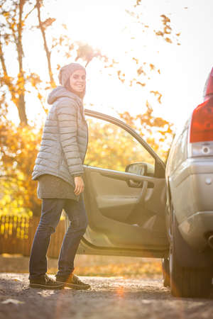Pretty young woman by her car ready for her daily commute to workの写真素材