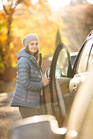 Pretty young woman by her car ready for her daily commute to workの写真素材