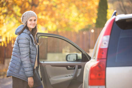 Pretty young woman by her car ready for her daily commute to workの写真素材