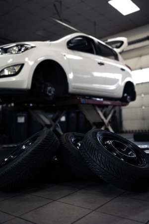 Car in a garage for maintenance, oil, tire change (shallow DOF; color toned image)の写真素材
