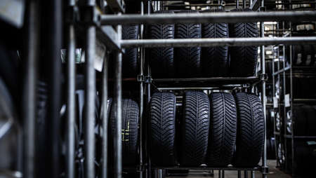 Tire change - wheel balancing or repair and change car tire at auto service garage or workshop by mechanicの写真素材