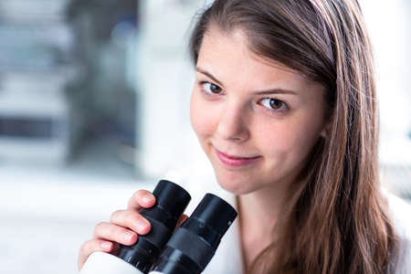Portrait of a female chemistry student carrying out research in a chemistry lab (color toned image;...