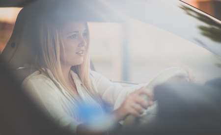 Pretty, young woman driving a car -Invitation to travel. Car rental or vacation.